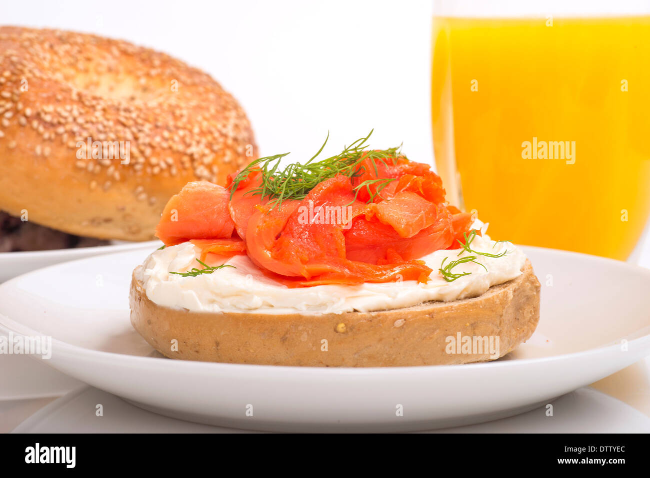 Bagel freschi con crema di formaggio e salmone e rabboccato con aneto servita con succo di arancia Foto Stock