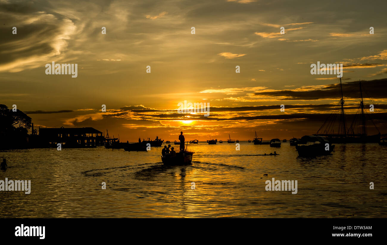 Silhouette di pescatori sulle rive dell'Oceano Indiano durante un tramonto Foto Stock
