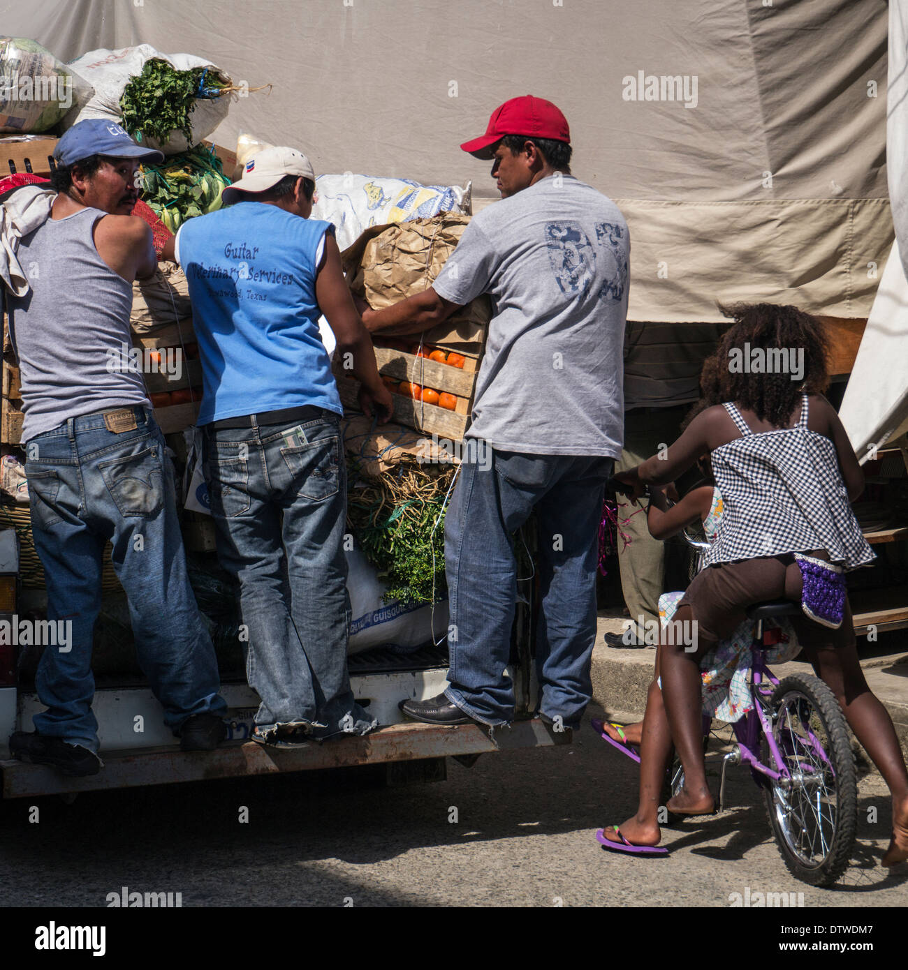 La gente ride un autocarro caricato con banane, Honduras Foto Stock