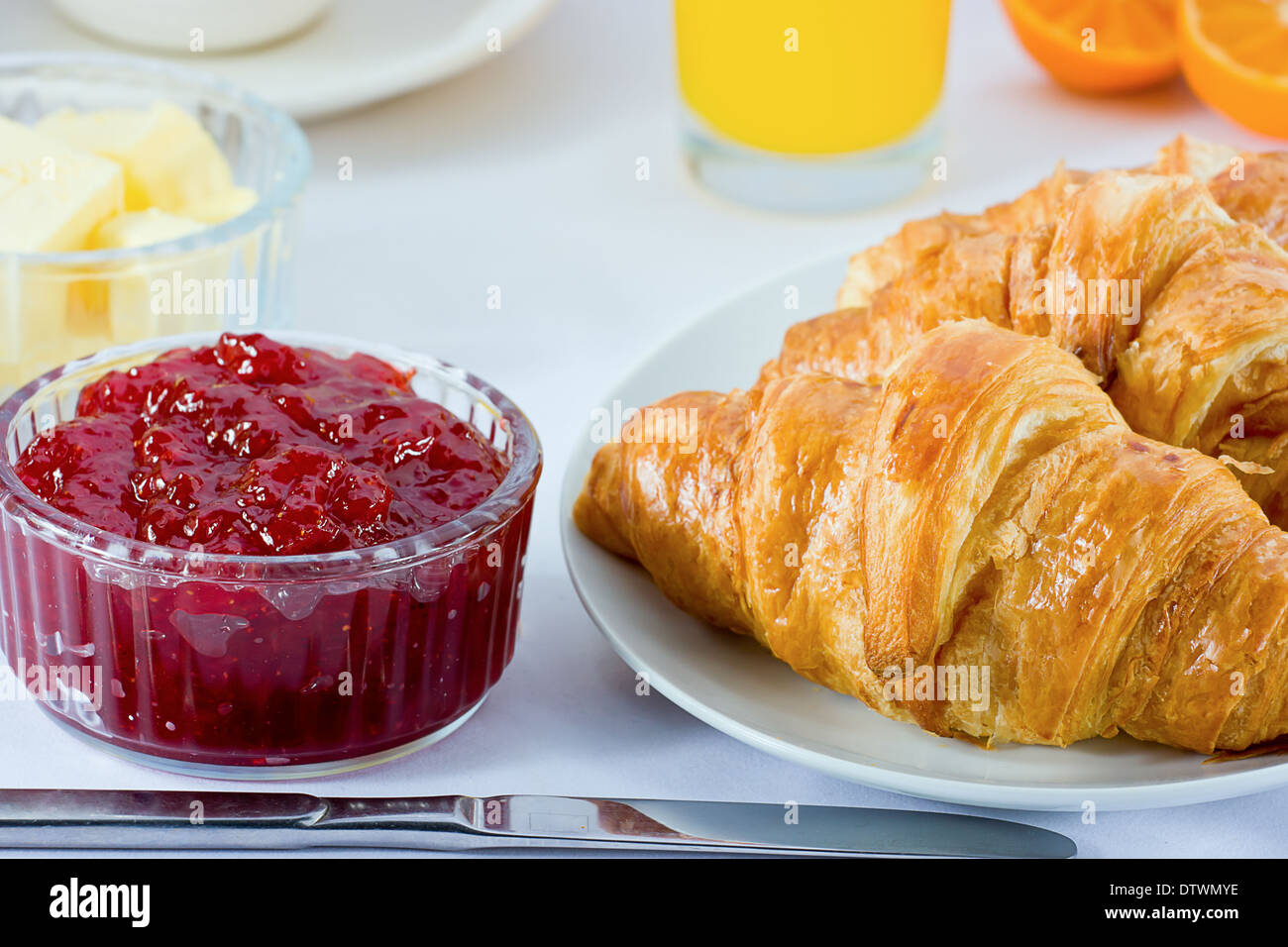 La prima colazione continentale con croissant, marmellata, succo di arancia, burro e succo di arancia. Foto Stock