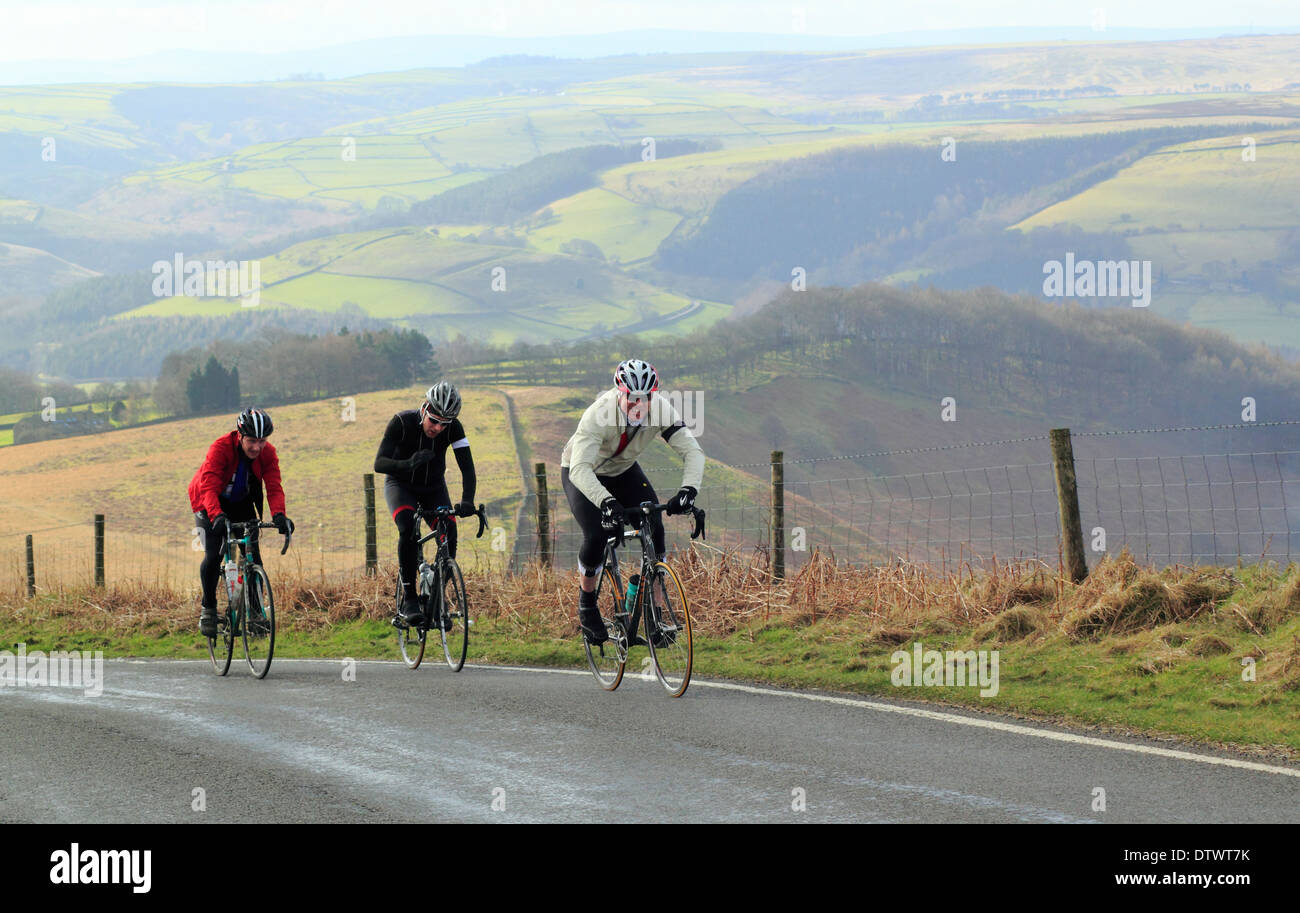 I ciclisti maschio ride fino Ringinglow Road, vicino a Sheffield, sopra Hathersage, Parco Nazionale di Peak District, Derbyshire, England, Regno Unito Foto Stock
