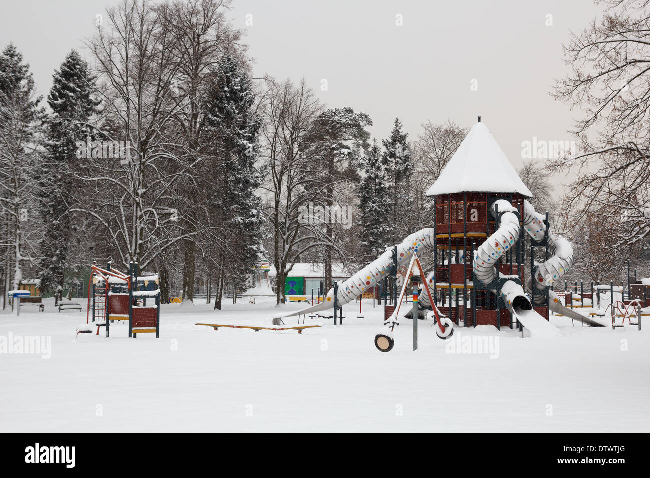 Coperta di neve il parco giochi per i bambini nel parco della città Foto Stock