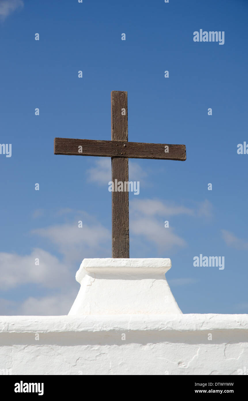 Croce di legno simbolo della religione in Spagna che è un paese cattolico contro un muro bianco e blu cielo Foto Stock