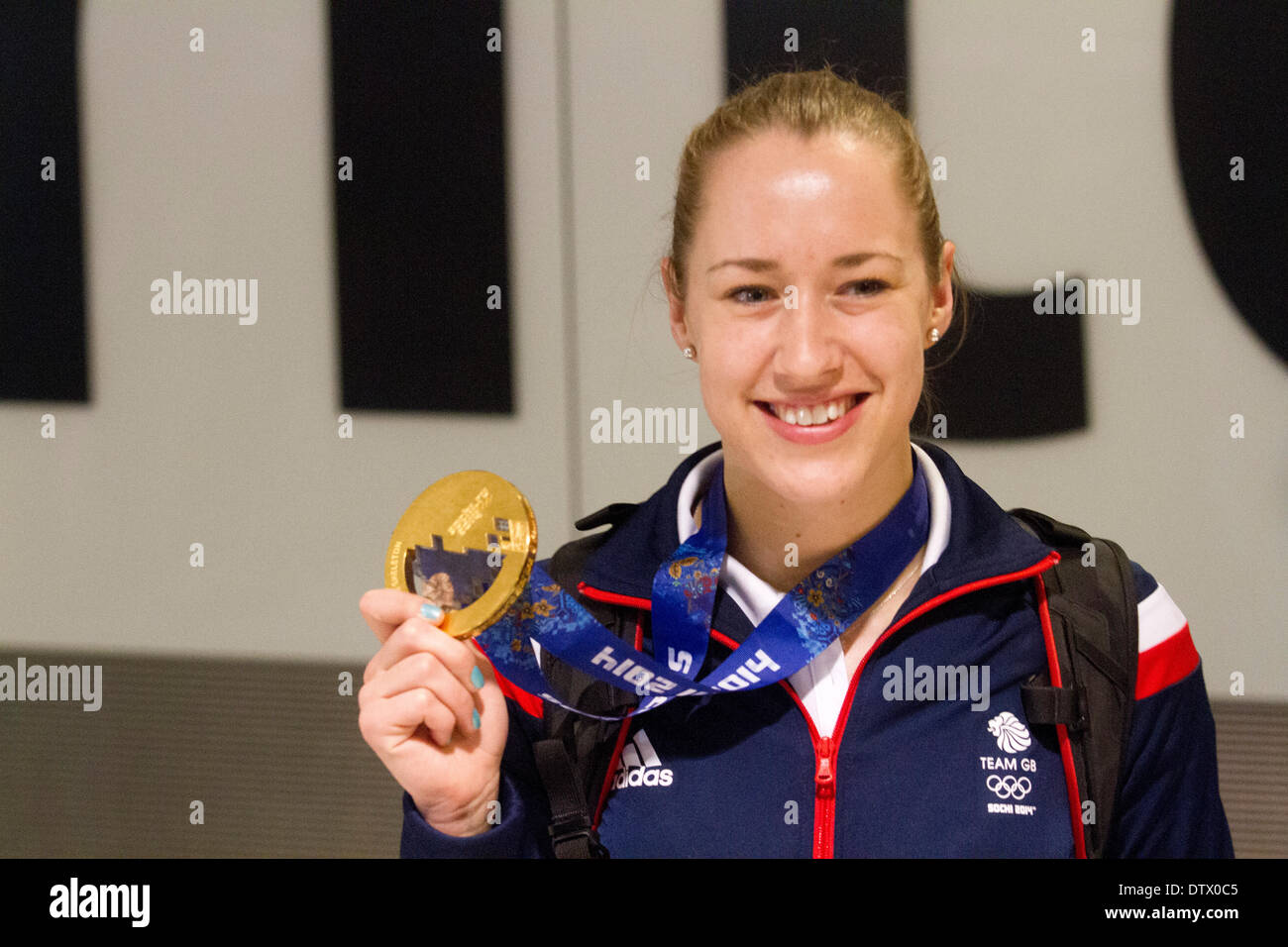 Aeroporto di Heathrow di Londra, Regno Unito. Il 24 febbraio 2014. Liz Yarnold vincitore della donna scheletro event arriva a Heathrow dal 2014 Olimpiadi invernali di Sochi indossando la sua medaglia d oro Credito: amer ghazzal/Alamy Live News Foto Stock