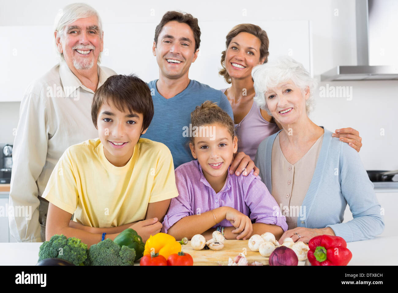 Tutta la famiglia sorridente in cucina Foto Stock