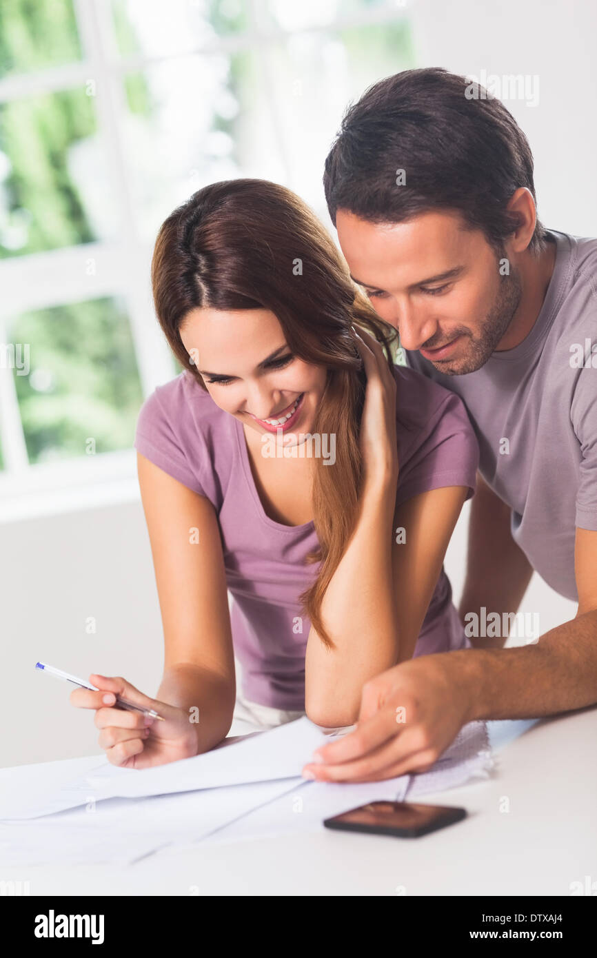 Coppia sorridente nella parte anteriore delle fatture Foto Stock