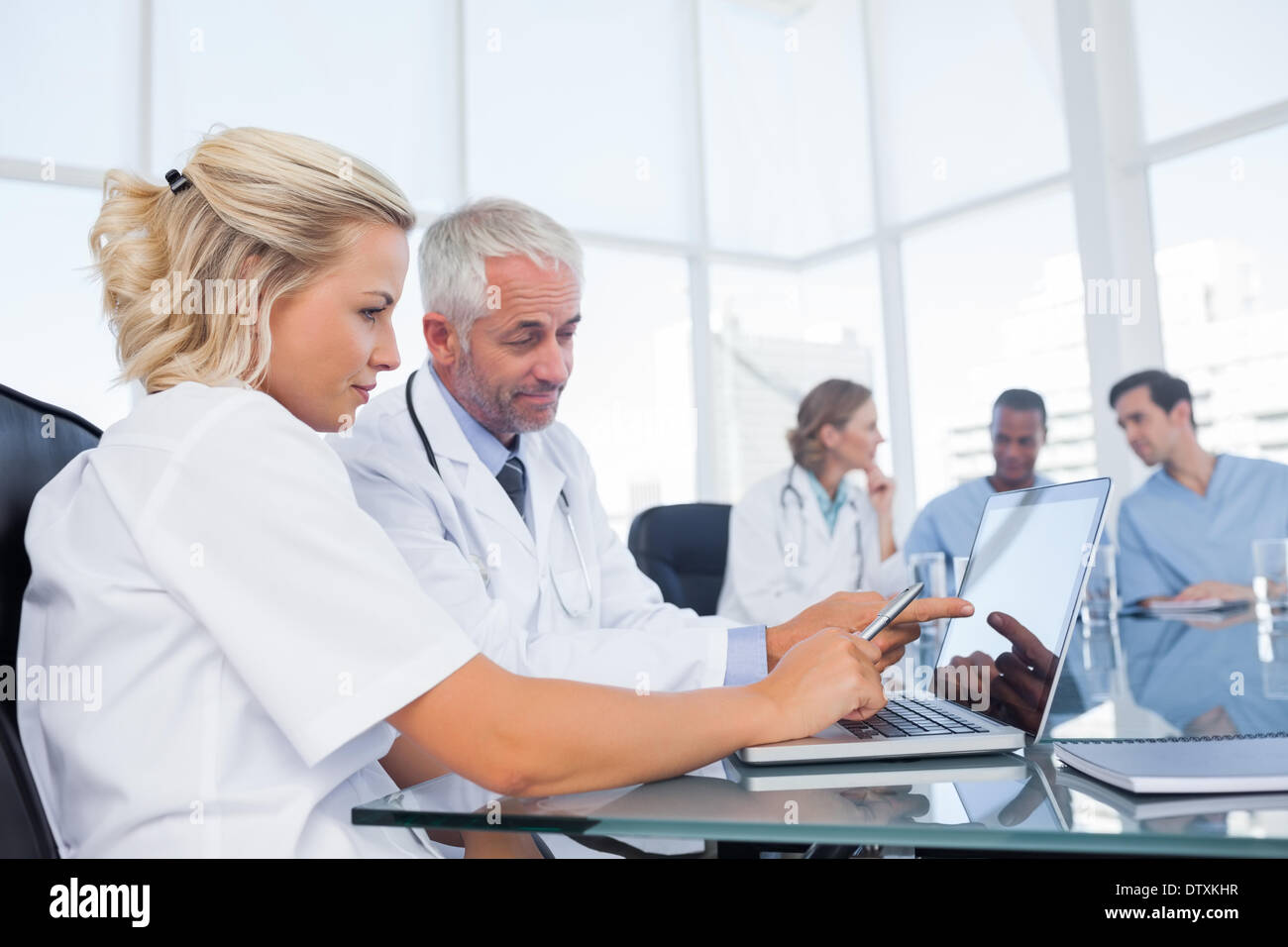 I medici usando un computer portatile Foto Stock