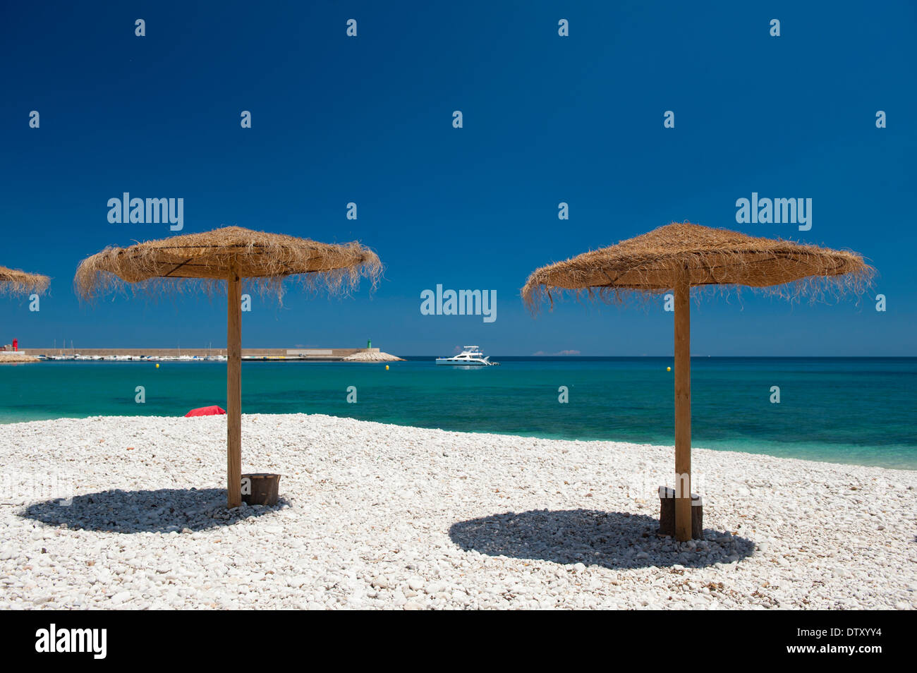 Tradizionale ombrelloni sulla spiaggia a Xabia, Spagna. Foto Stock