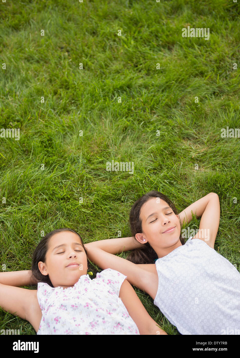 Razza mista ragazze posa in erba Foto Stock