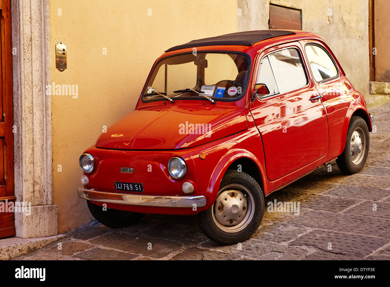 Rosso Fiat 500 parcheggiate fuori una casa in Toscana a Montepulciano, Toscana, Italia Foto Stock