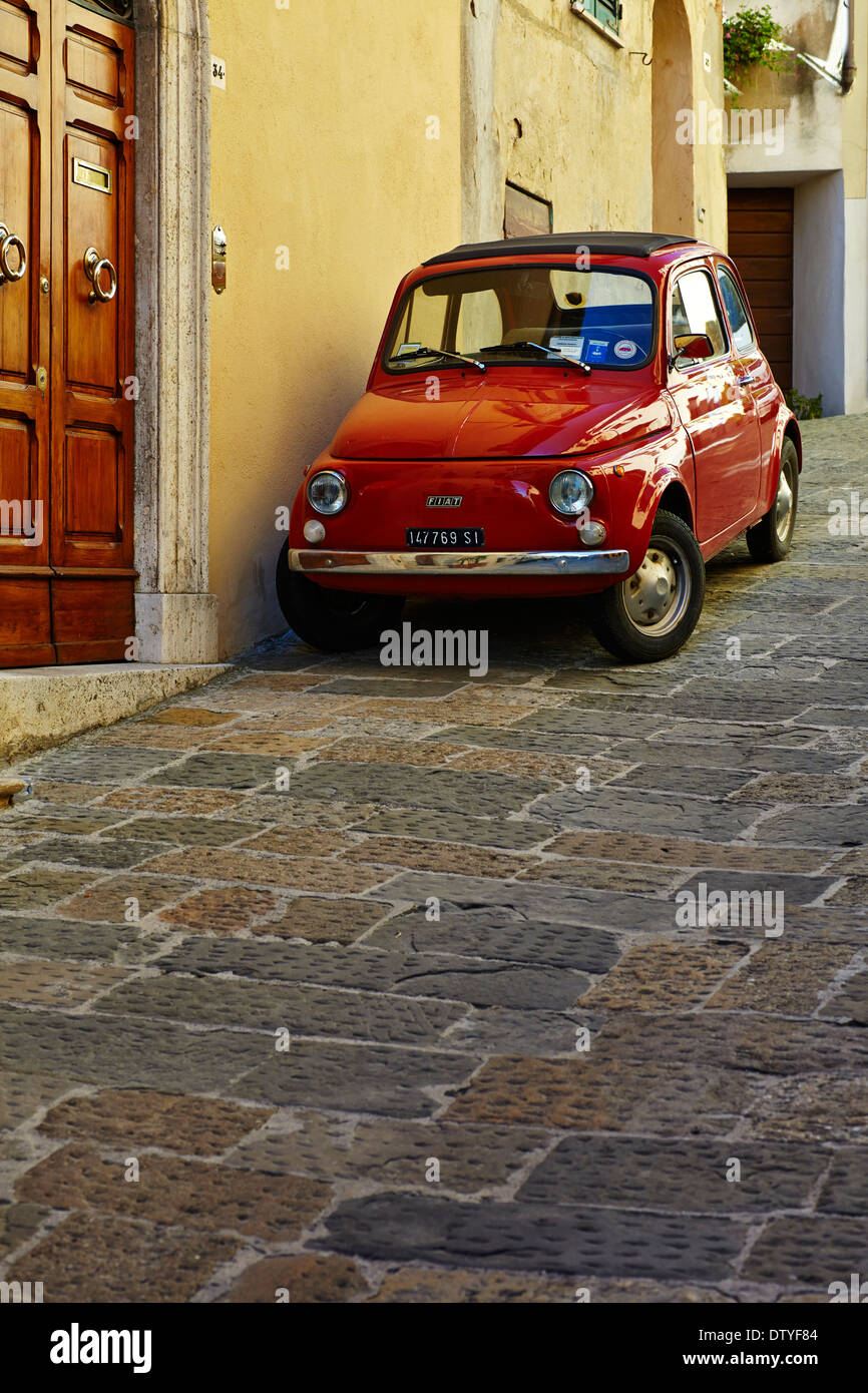 Rosso Fiat 500 parcheggiate fuori una casa in Toscana a Montepulciano, Toscana, Italia Foto Stock