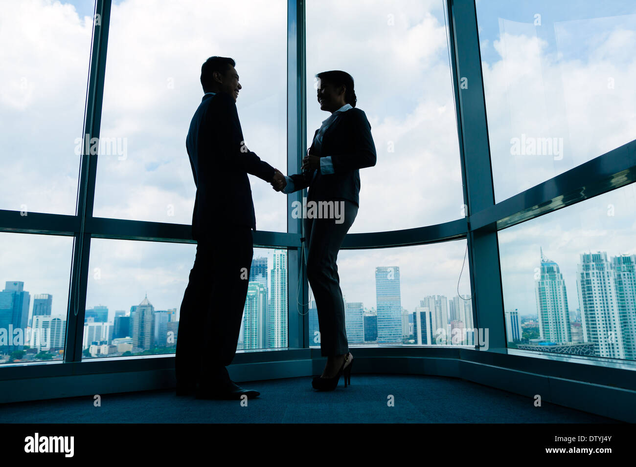 Asian business persone handshake tenuta a trattare di fronte dello skyline della città Foto Stock