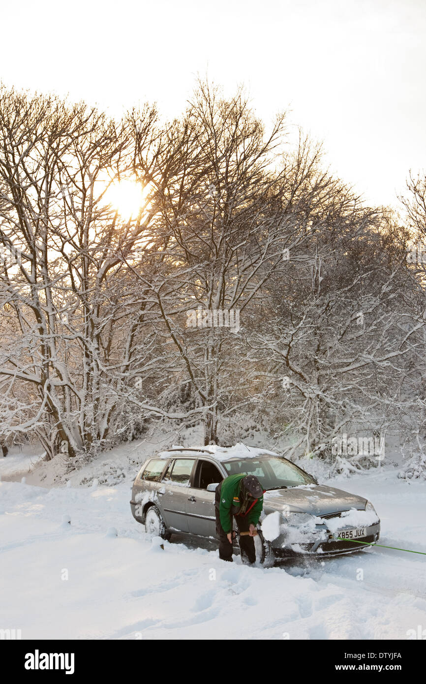 Auto conducente bloccato nella neve lo scavo di auto Foto Stock