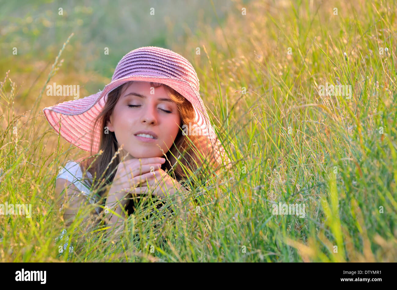 La ragazza si trova tra i fiori selvatici in estate Foto Stock