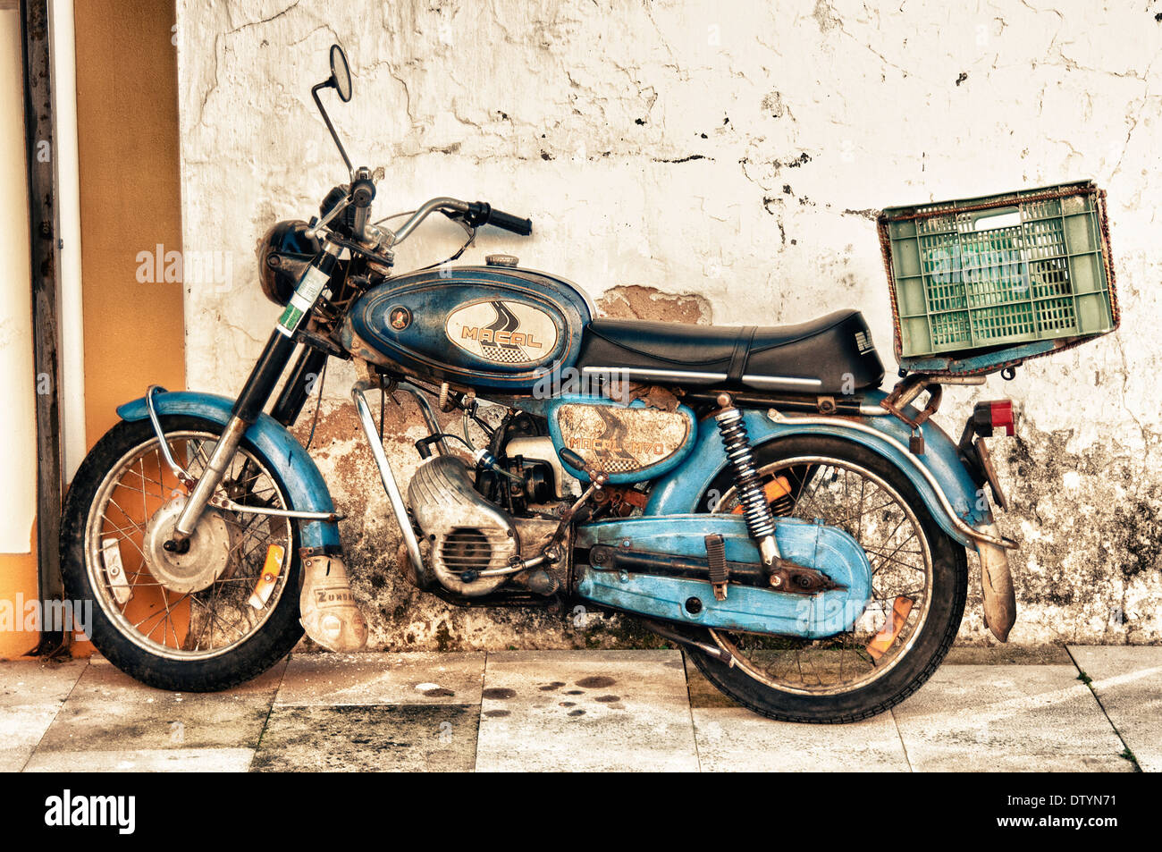 Vintage vecchia motocicletta poggiante contro una parete Foto Stock