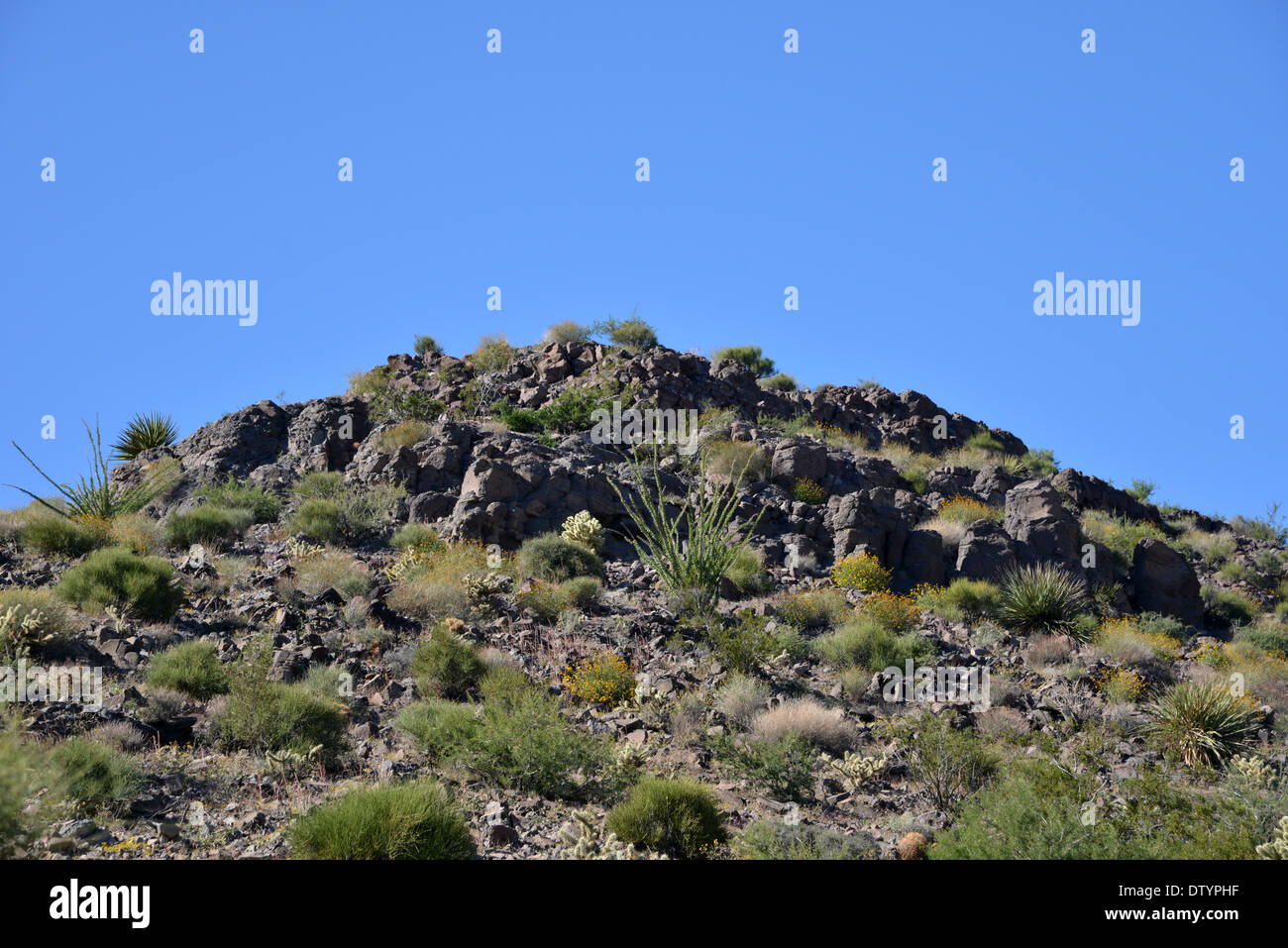 Rocce e macchia nelle colline attorno a "la strega capezzolo dell' rock formazione vicino Kingman, Arizona, lungo la vecchia strada 66 Foto Stock