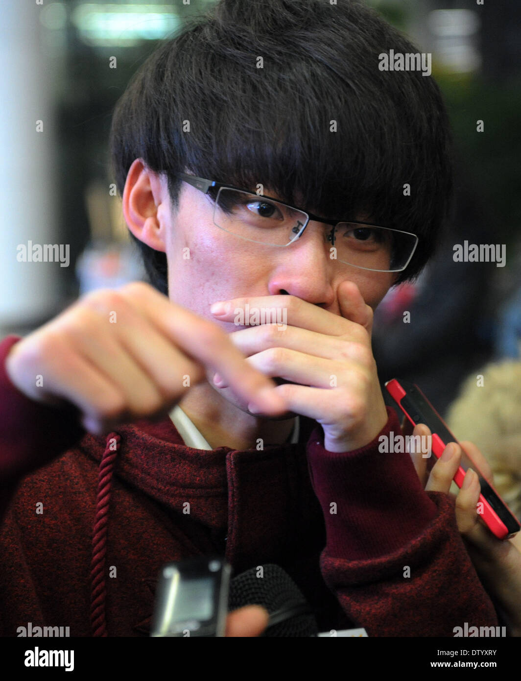 (140225) -- SHENYANG, Feb 25, 2014 (Xinhua) -- un passeggero racconta la storia dell'incidente a Shenyang Taoxian Aeroporto Internazionale di Shenyang City, la capitale del nord-est della Cina di Provincia di Liaoning, Feb 25, 2014. Un volo vincolato per Shenyang City del nord-est della Cina di Provincia di Liaoning ha effettuato un atterraggio riuscito dopo un guasto dello strumento è costretto a ritardare la discesa. Volo BK2870, azionato da Okay Airways Company Ltd con sede a Pechino, sbarcati con successo a Shenyang Taoxian Aeroporto Internazionale a 8:24 p.m., più di due ore e mezzo più tardi del tempo programmato, un portavoce w Foto Stock