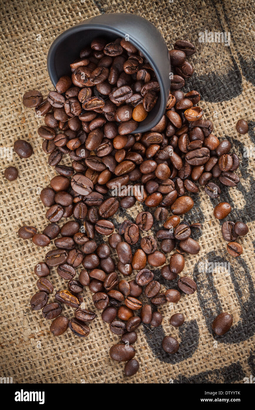 Schizzi di caffè in grani e coppa del nero Foto Stock