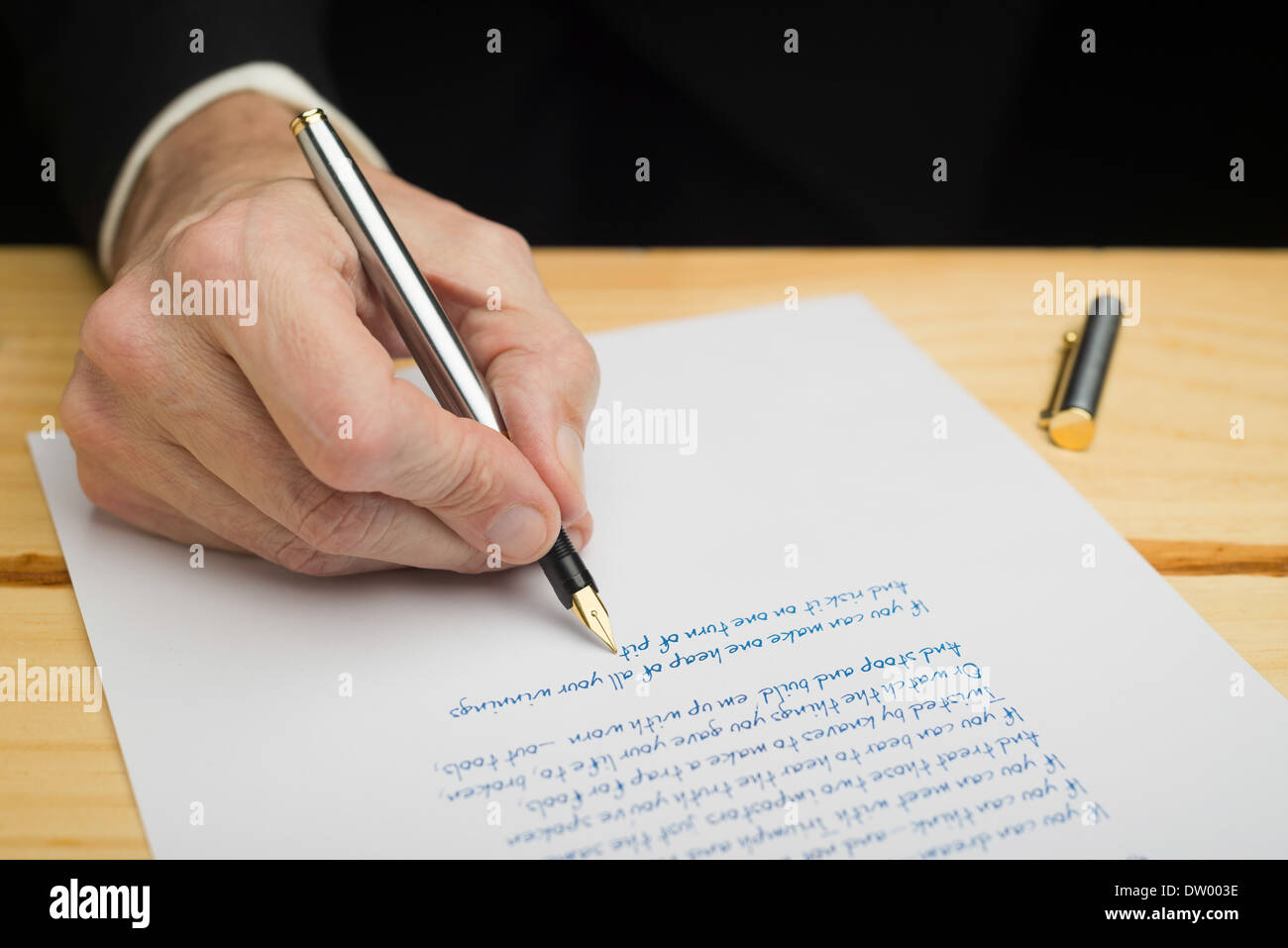 Un imprenditore scrivere con una penna stilografica su un foglio di carta  bianca impostato su una collina boscosa deck Foto stock - Alamy