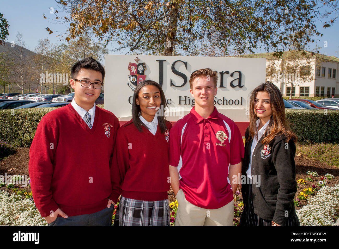 Caucasici, americano asiatico e americano africano uniformata agli studenti di socializzare sul campus di un privato scuola superiore cattolica. Foto Stock