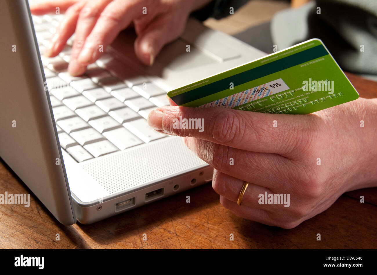 Persona in possesso di carta di credito con il computer portatile Foto Stock