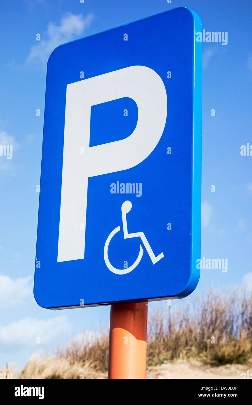 Close up di blu simbolo di parcheggio per disabili in sedia a rotelle al parcheggio auto Foto Stock