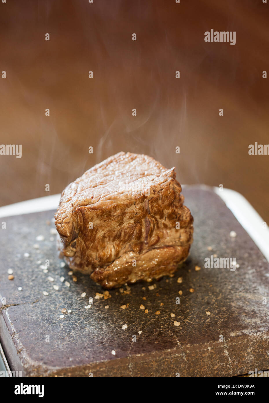 Bistecca sfrigolante su pietra calda piastra Foto Stock