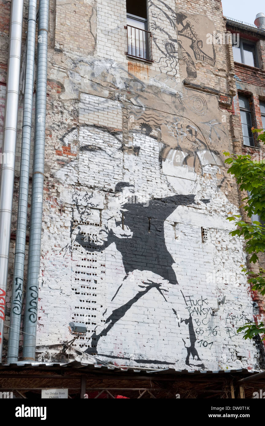 Grafitti raffigurante un uomo lanciare una bomba su una parete in corrispondenza di Kunsthaus Tacheles a Berlino, Germania. Foto Stock