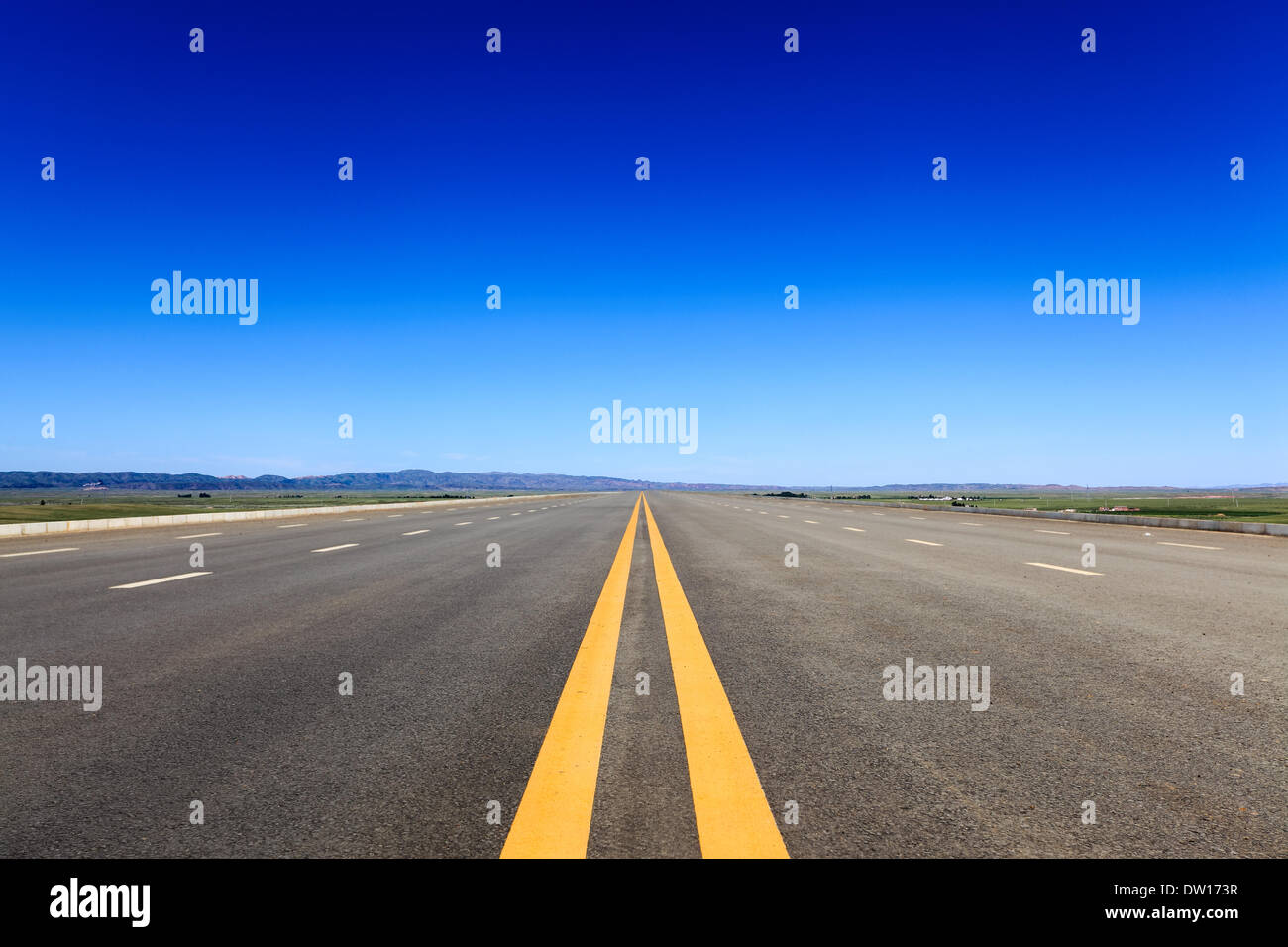 Autostrada nella steppa contro un cielo blu Foto Stock
