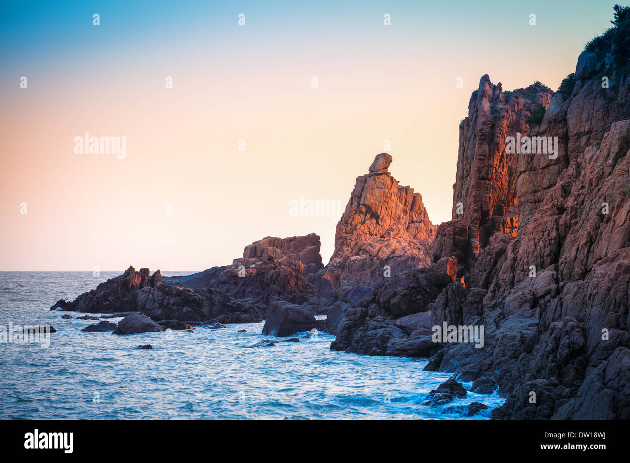 Sunrise luce che risplende sulla barriera corallina rock Foto Stock