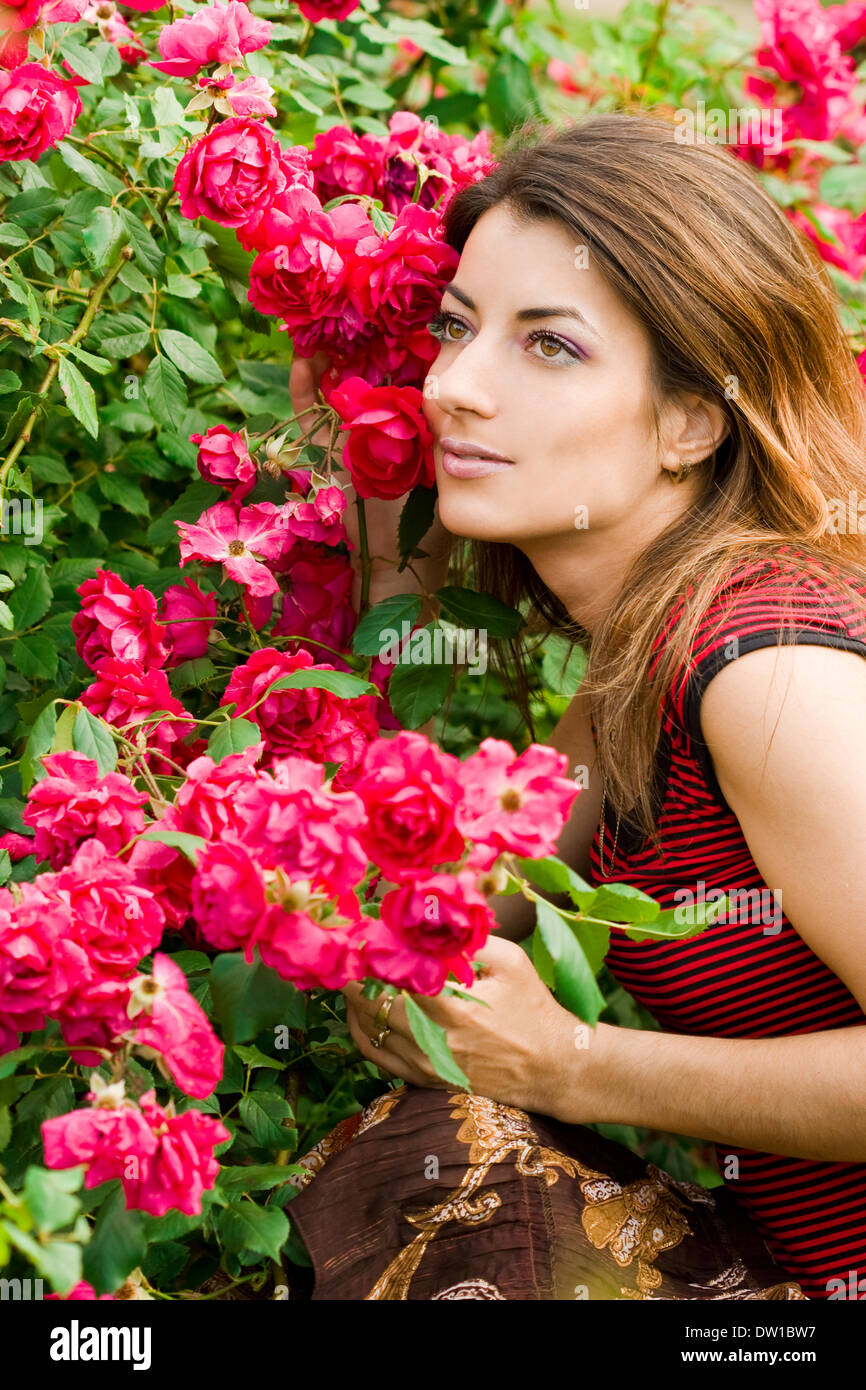 Bella donna in giardino con rose Foto Stock