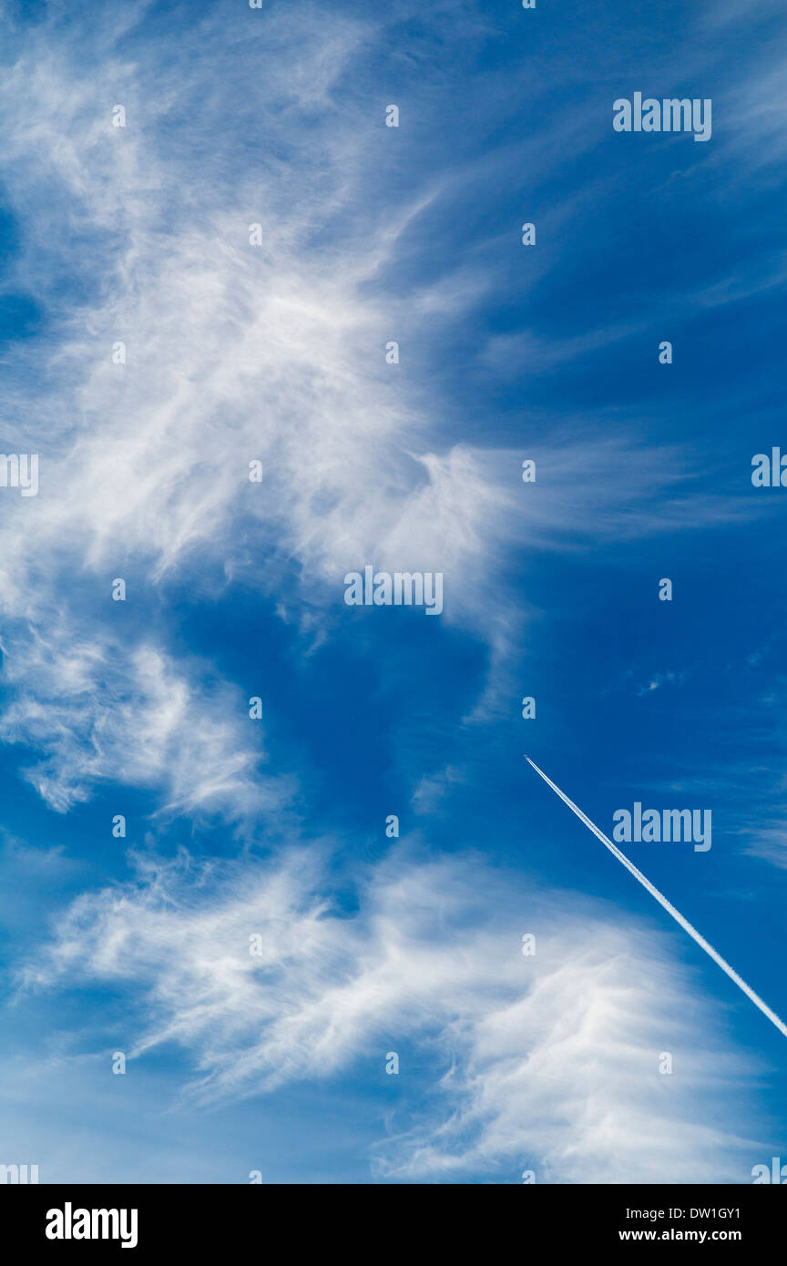 Jet contrails wispy e nuvole bianche nei confronti di un blu limpido azzurro cielo Colorado Foto Stock