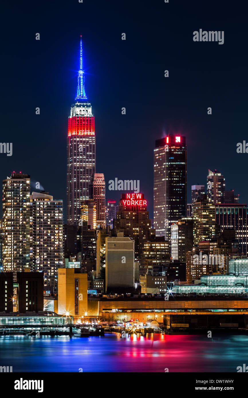Empire State Building di notte. La parte superiore dell'iconico grattacielo visualizza la bandiera americana colori, blu-bianco-rosso, in onore di Foto Stock