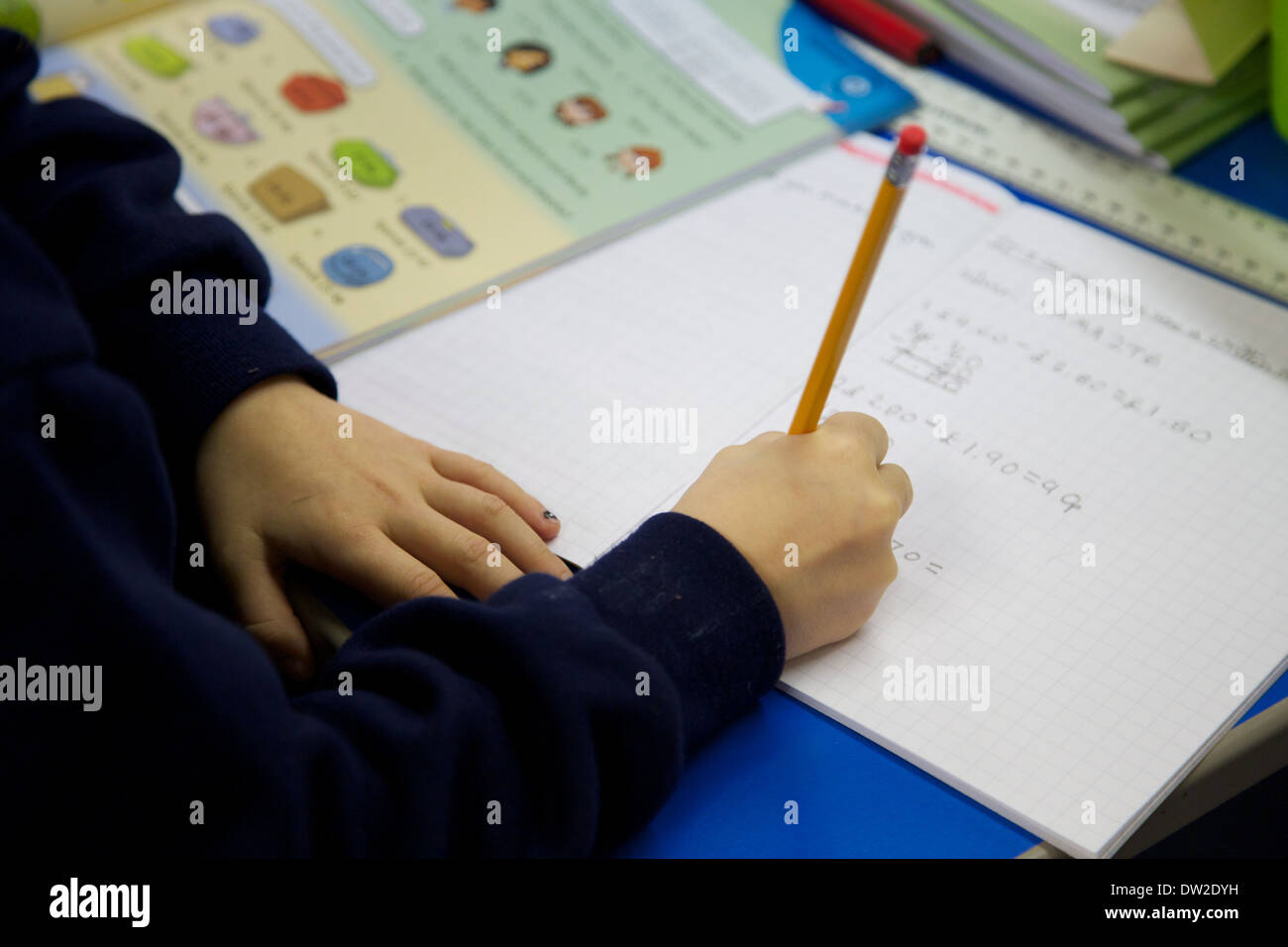 Regno Unito schoolchild lavorando in Inghilterra inglese scuola primaria con i loro libri di esercizio Foto Stock