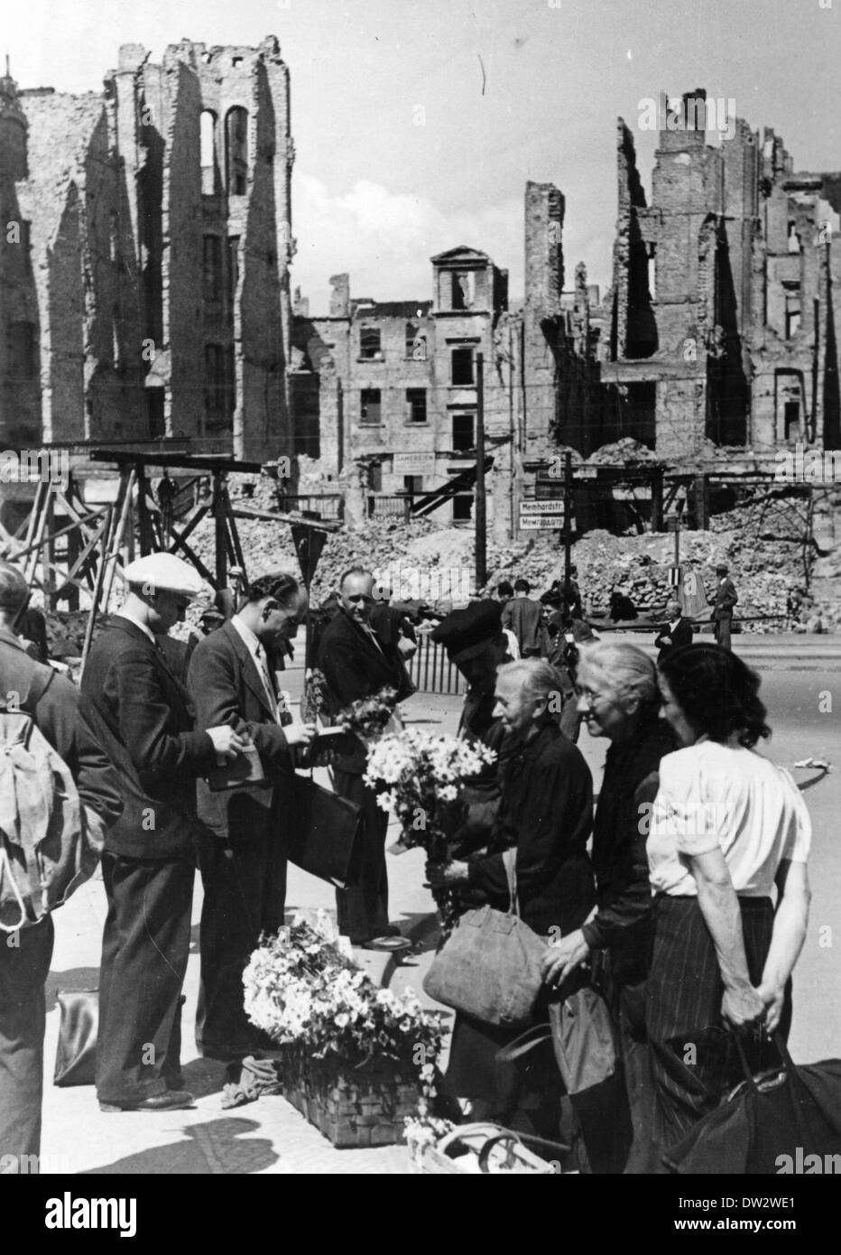 La gente torna alla normalità in un ambiente anormale - le donne vendono fiori di fronte alle rovine di case in via Memhardstrasse vicino Alexanderplatz a Berlino, maggio 1945. Fotoarchiv für Zeitgeschichte - SENZA FILI Foto Stock