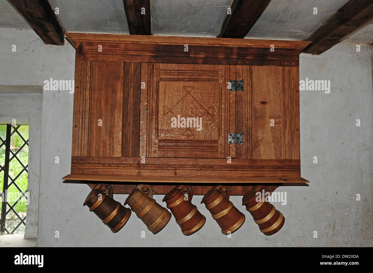 La riproduzione brocche appeso al di sotto di un armadio a muro in un diciassettesimo secolo la casa al Weald and Downland Open Air Museum. Foto Stock