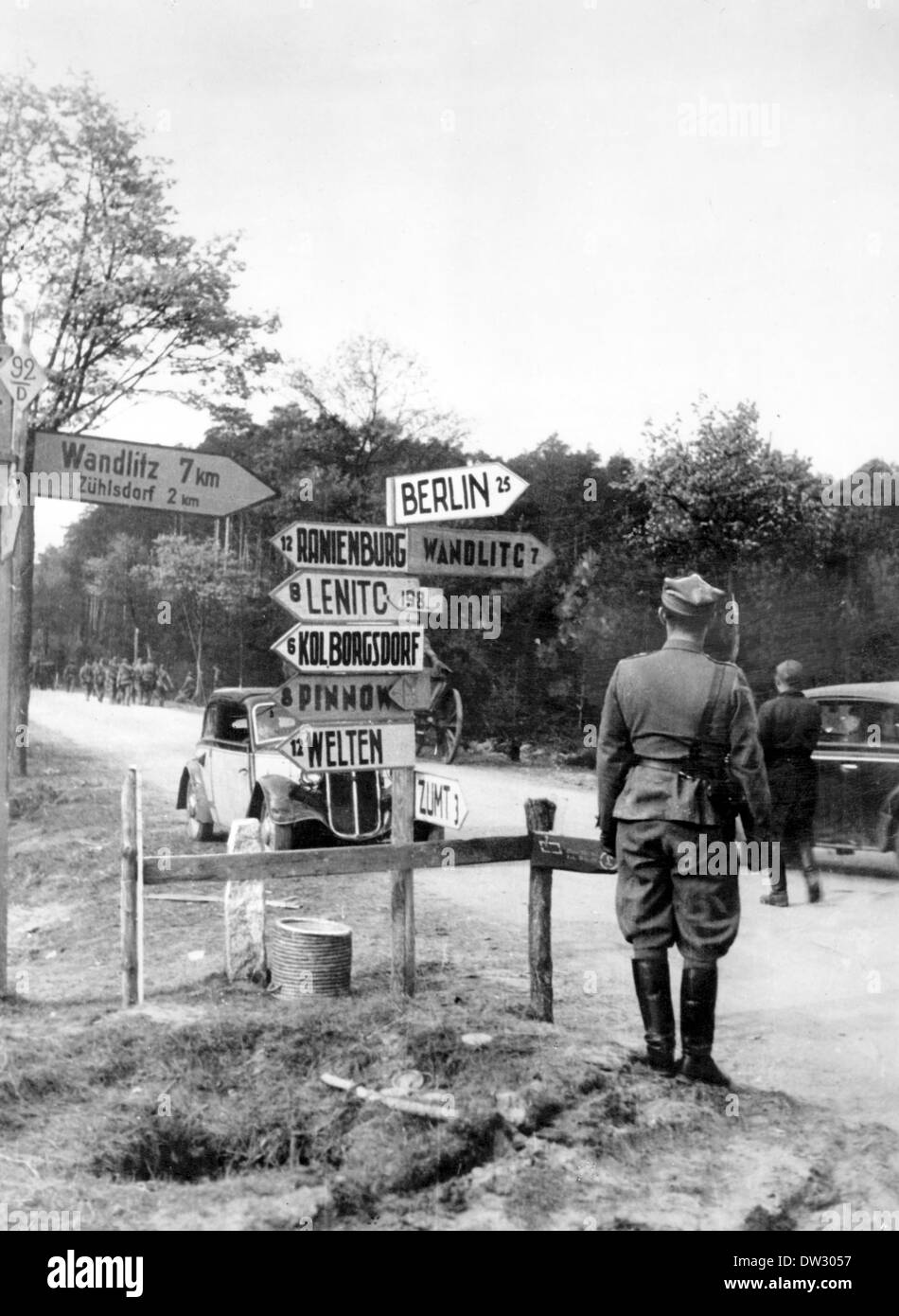 Fine della guerra a Berlino 1945 - i soldati polacchi e sovietici si trovano di fronte alle indicazioni che indicano la strada per Berlino (25 km), Wandlitz (7 km), Zuehlsdorf (2 km), Oranienburg (12 km), Lenitc (Lehnitz, 8 km), Borgsdorf (6 km), Pinnow (8 km), Welten (Velten, 12 km) e Zumt (Summt 3 km). Fotoarchiv für Zeitgeschichtee - NESSUN SERVIZIO DI CABLAGGIO Foto Stock