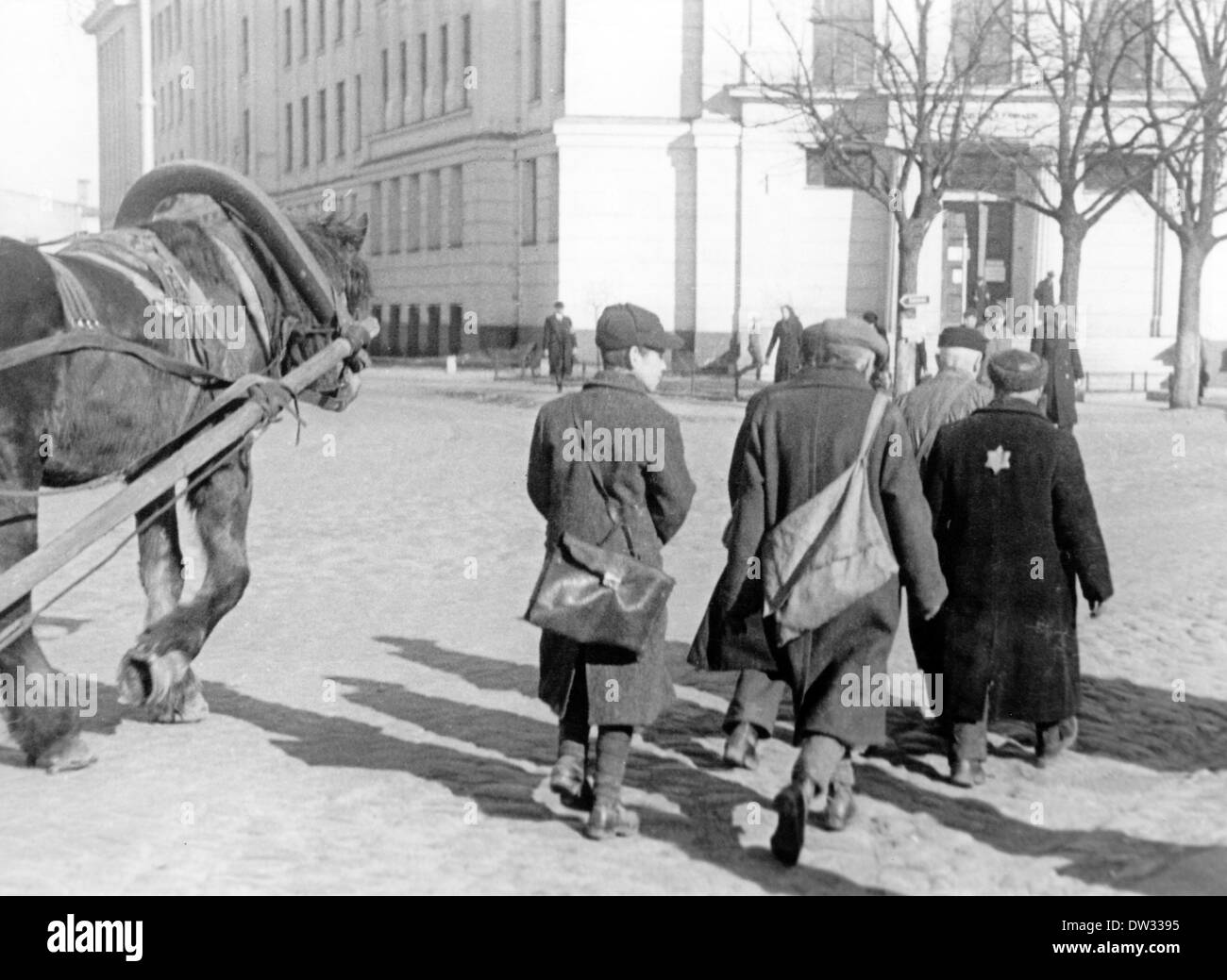 Gli ebrei camminano lungo una carrozza trainata da cavalli su una strada nel ghetto di riga. Scena da riga (Lettonia) al momento dell'occupazione tedesca dal 1941 al 1944. Dopo la conquista di riga da parte della Wehrmacht tedesca, il comando di occupazione di riga decise di concentrare i lavoratori ebrei in un ghetto il 21 luglio 1941. Tutti gli ebrei furono registrati e dovettero indossare una Stella di Davide, anche loro non poterono usare i marciapiedi. Fotoarchiv für Zeitgeschichtee / NESSUN SERVIZIO DI CABLAGGIO Foto Stock