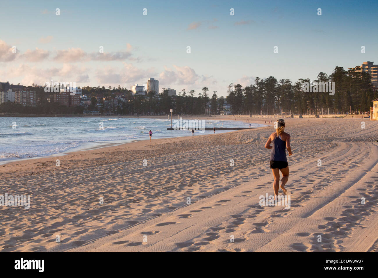 Manly North Steyne Beach all'alba con femmina pareggiatore di runner che corre lungo la sabbia Sydney New South Wales NSW Australia Foto Stock