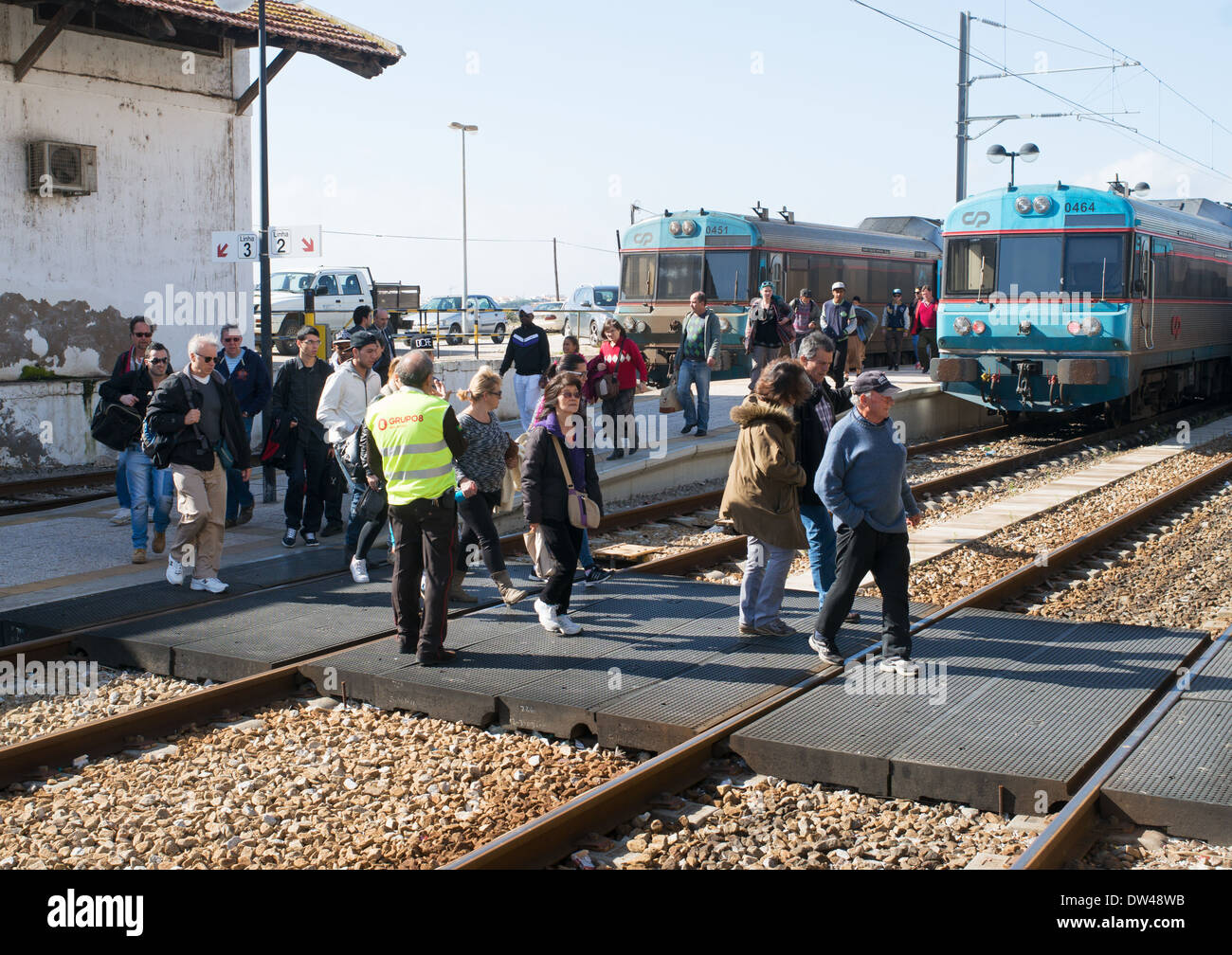 I passeggeri che attraversano la linea ferroviaria sotto la supervisione, Faro rail station Algarve Portogallo, Europa Foto Stock