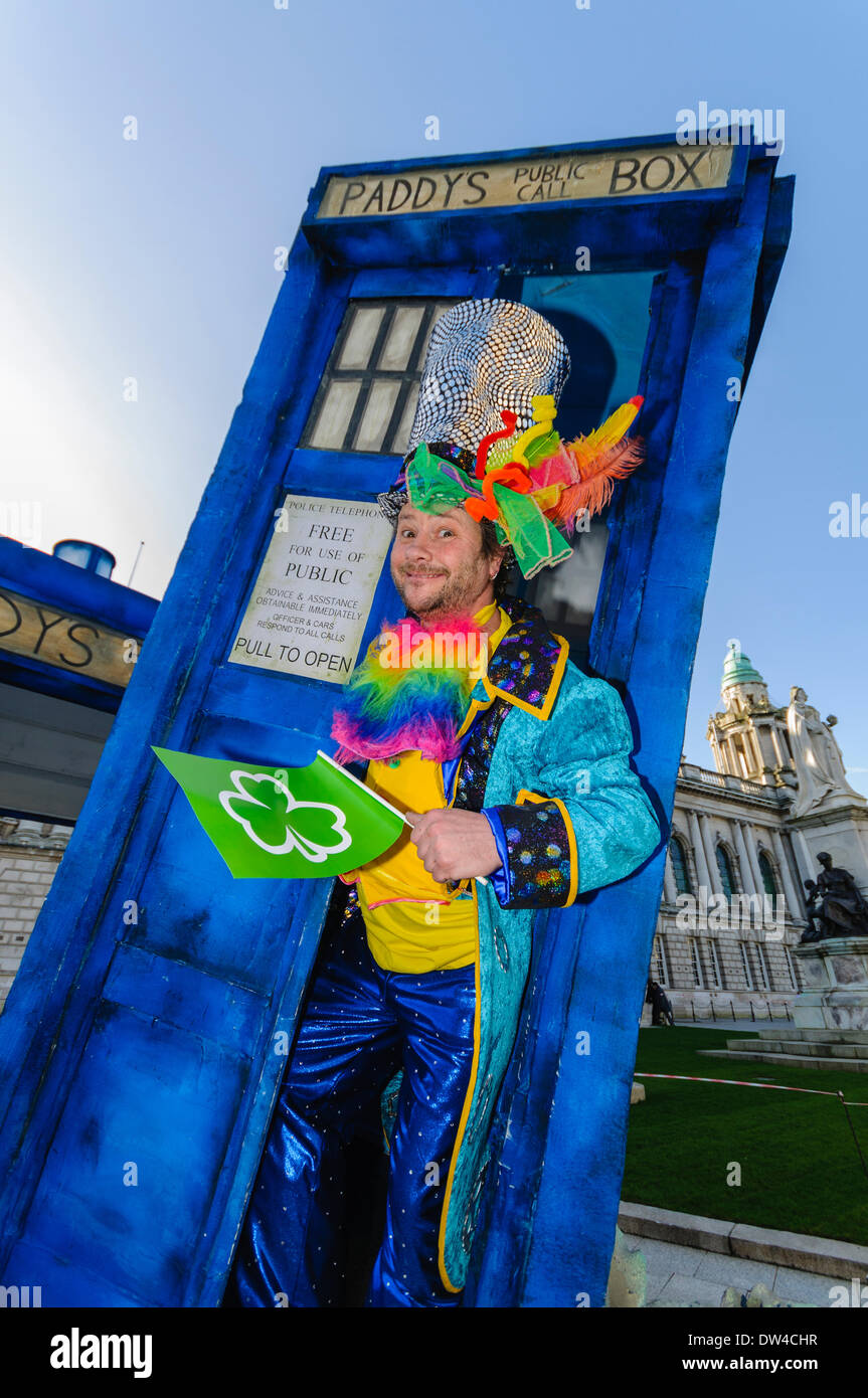 Un uomo vestito in abiti colorati emerge da un 'Tardis' a un il giorno di San Patrizio evento Foto Stock