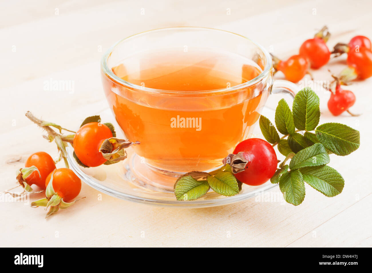 Rosa tè alle erbe nella coppa in vetro e di rosa canina frutti Foto Stock