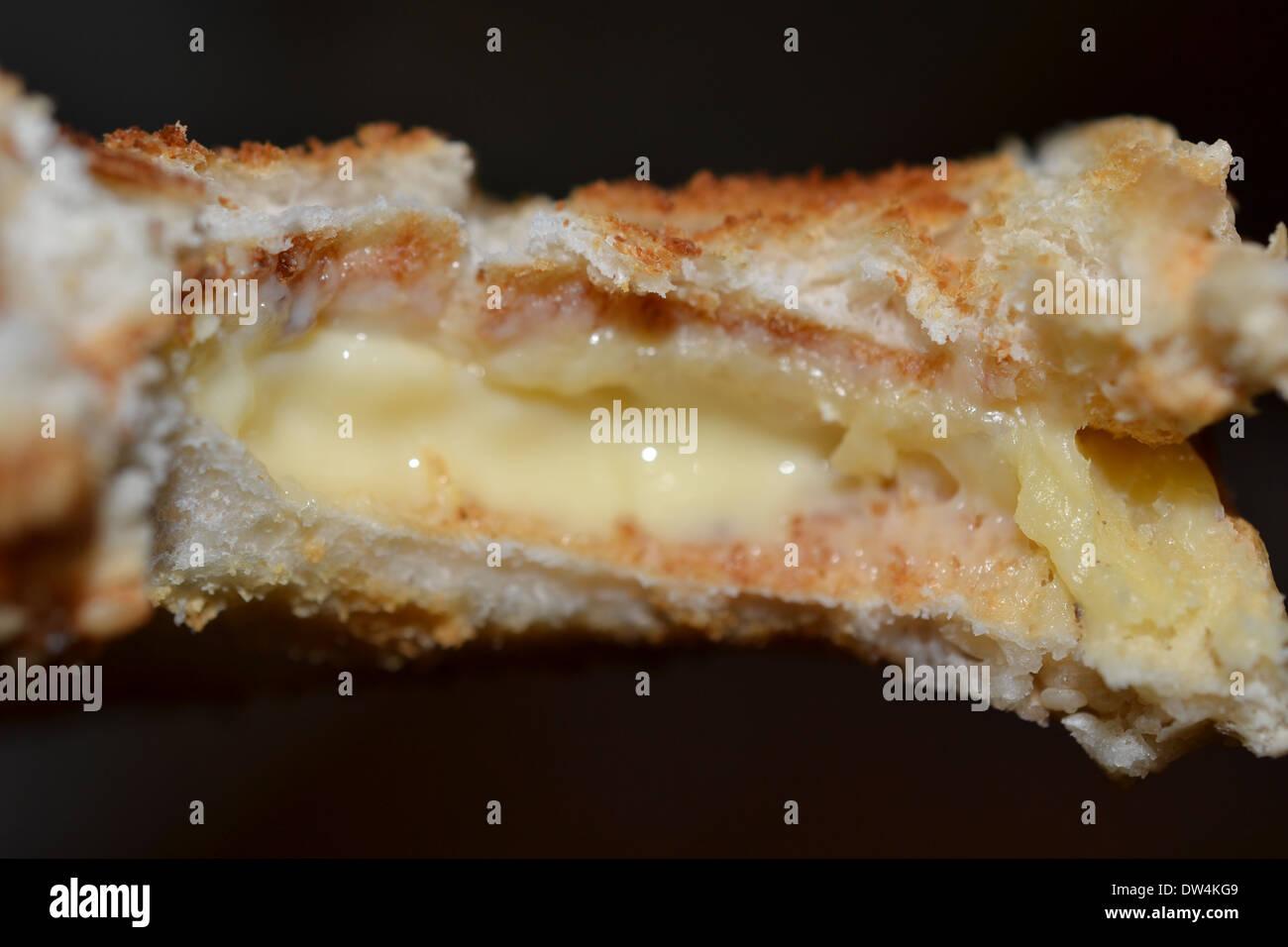 Vista dettagliata del formaggio fuso tostare sandwich con un morso preso fuori di esso Foto Stock