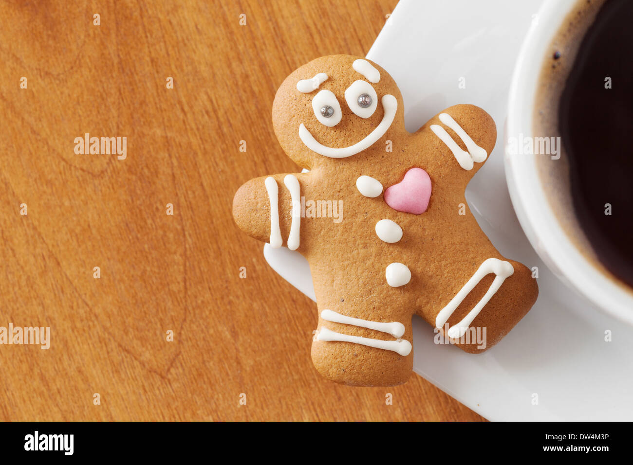 Sorridente omino di pan di zenzero e la tazza di caffè sul tavolo Foto Stock