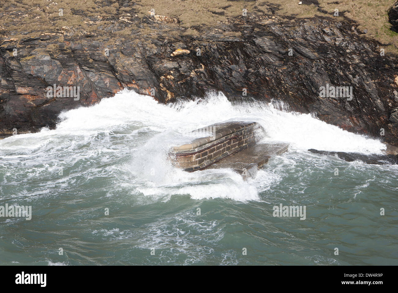 Alta Marea sulla costa nord della Cornovaglia al piccolo porto di pesca di Boscastle come le onde si infrangono sulla barriera esterna Foto Stock