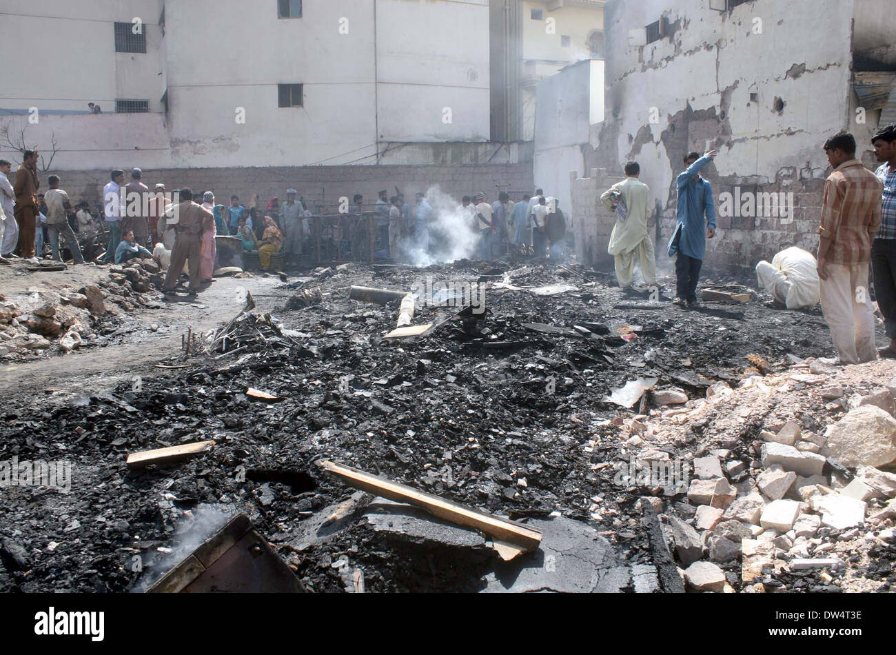 Vista della baraccopoli di bruciato dopo l'estinzione incendio scoppiato in un appartamento residenziale di un multi-edificio storeyed nel mercato di mobili di Gharibabad, a Karachi il giovedì 27 febbraio, 2014. Foto Stock