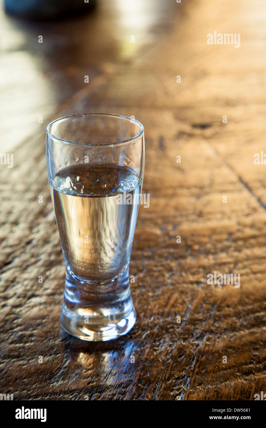 Single shot di Tequila sulla tavola di legno Foto Stock