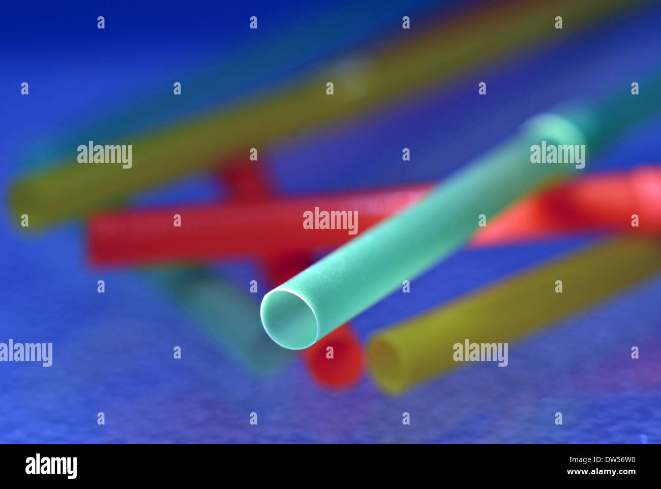 Macro shot di cannucce colorate seduto su un vetro tagliere Foto Stock