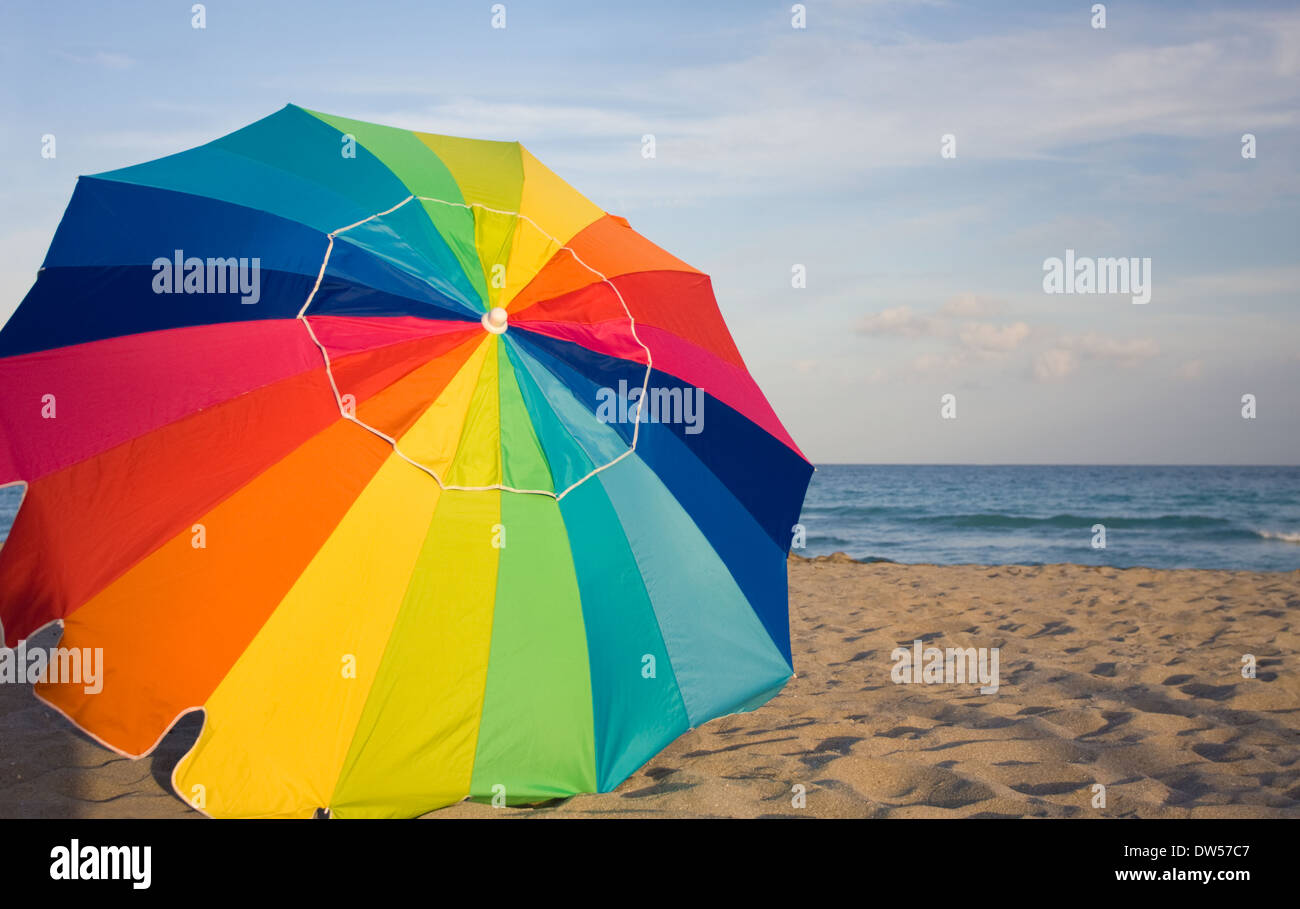 Ombrello multicolore sulla spiaggia Foto Stock