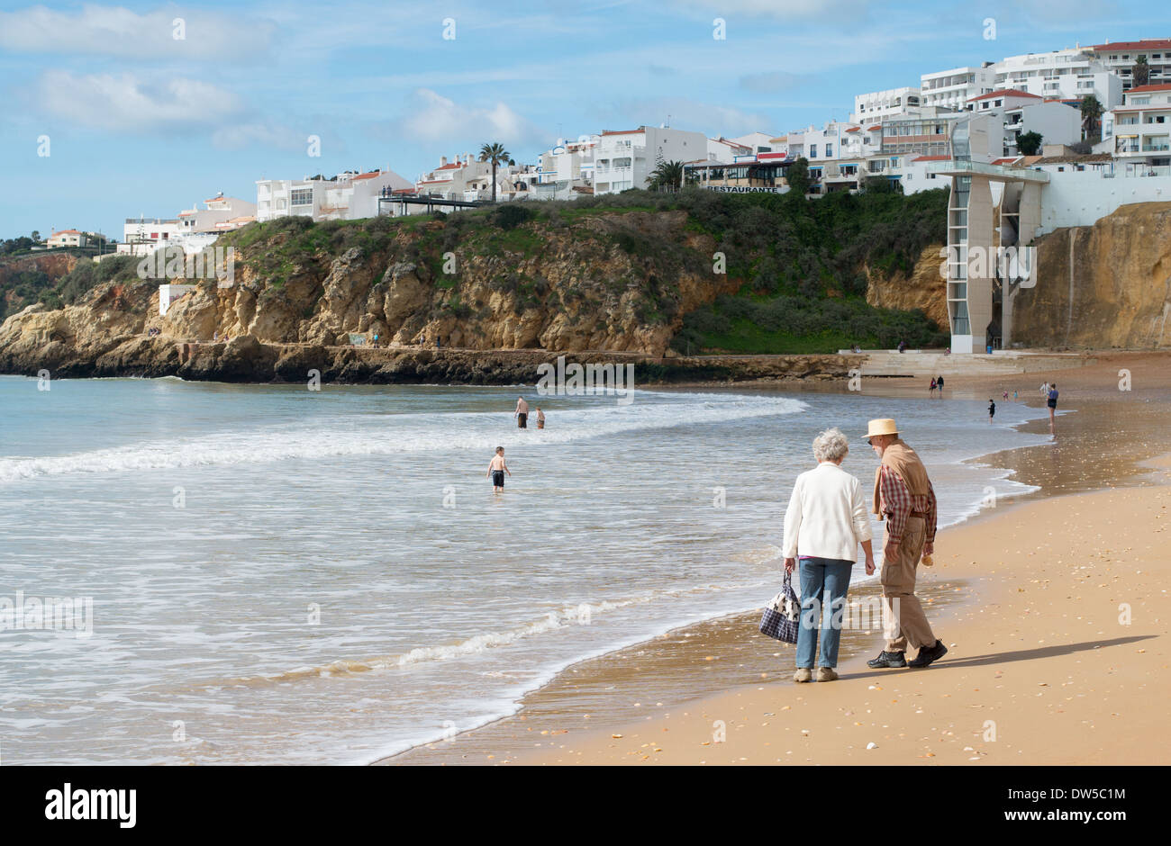 Coppia senior a piedi lungo la spiaggia di Albufeira, Algarve, Portogallo, Europa Foto Stock